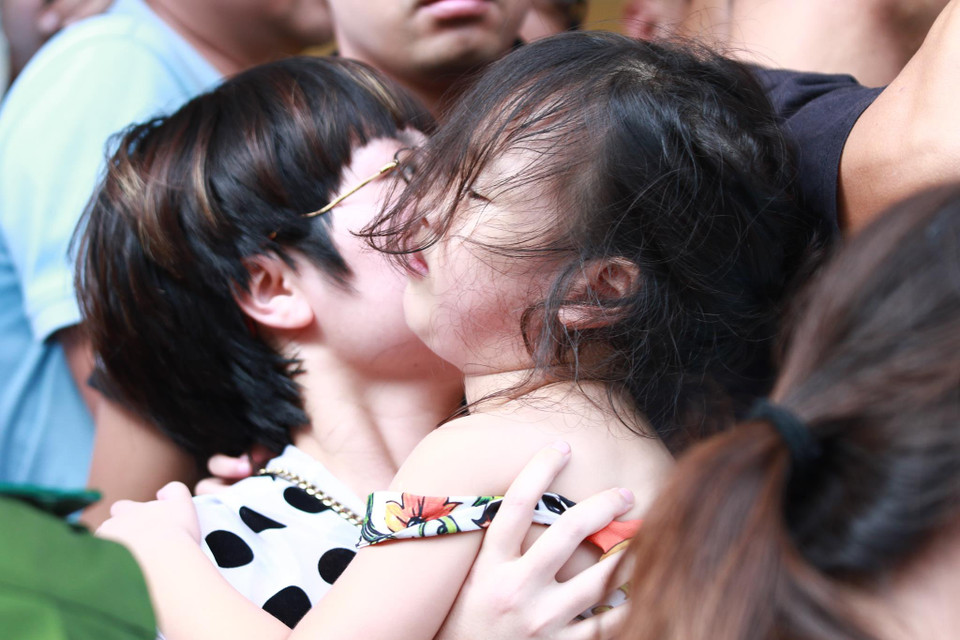 Hình ảnh ghi lại khoảnh khắc em nhỏ được em bế giữa đám người chen nhau bên ngoài sân Thiên Trường trước trận đấu Nam Định với Hoàng Anh Gia Lai. (Ảnh: Nguyên An)