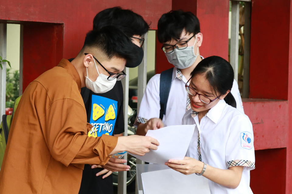 Một nhóm thí sinh cười tươi khi so đáp án trùng khớp với nhau. Các em cho biết bản thân đều làm được bài và cảm nhận đề thi năm nay không quá khó. (Ảnh: Phúc Tá/Vietnam+)