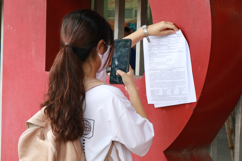  Trong ảnh, một em gái chụp ảnh đề thi và đáp án của mình để gửi về cho cô giáo chấm điểm và nhận định bản thân được khoảng 9 điểm môn thi Tiếng Anh. (Ảnh: Phúc Tá/Vietnam+)