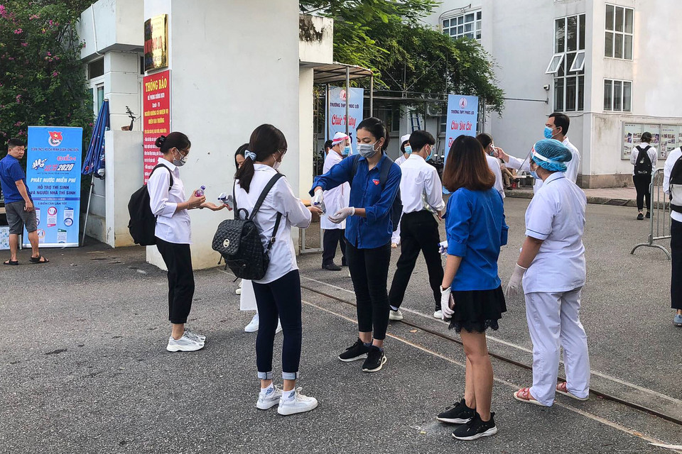 Mỗi thí sinh tới điểm thi trong kỳ thi tốt nghiệp THPT được đo thân nhiệt cẩn thận, rửa tay bằng nước sát khuẩn, phát khẩu trang, nước và bút miễn phí. (Ảnh: PV/Vietnam+)