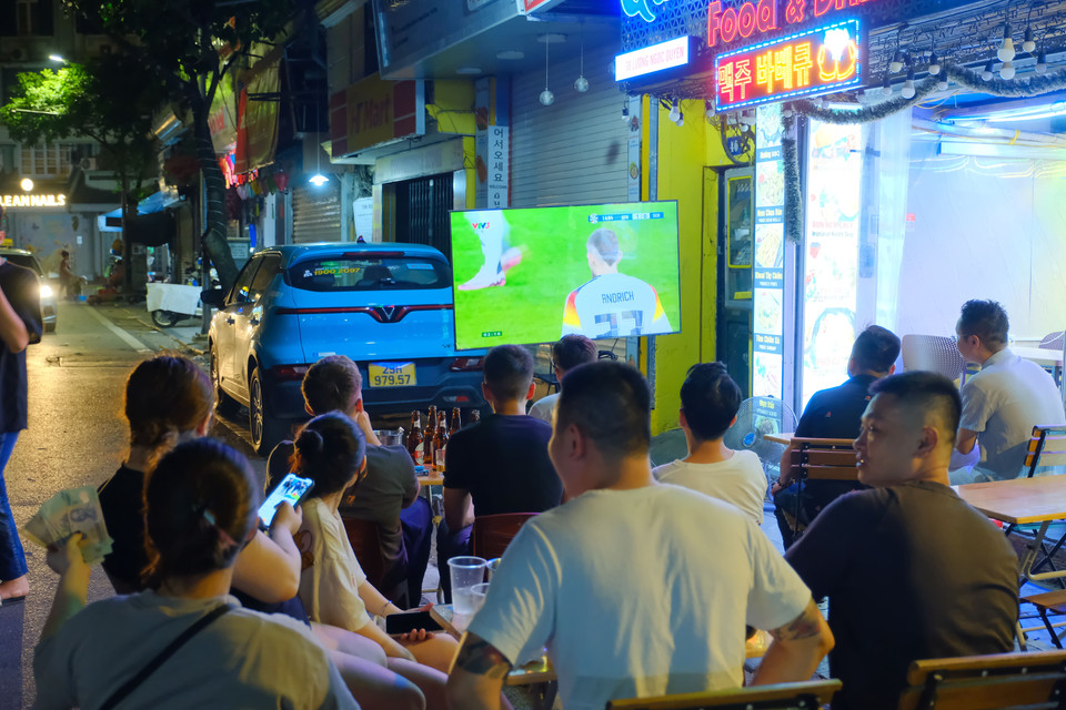 Các hàng quán lắp đặt TV để "chiều lòng" người hâm mộ. (Ảnh: PV/Vietnam+)