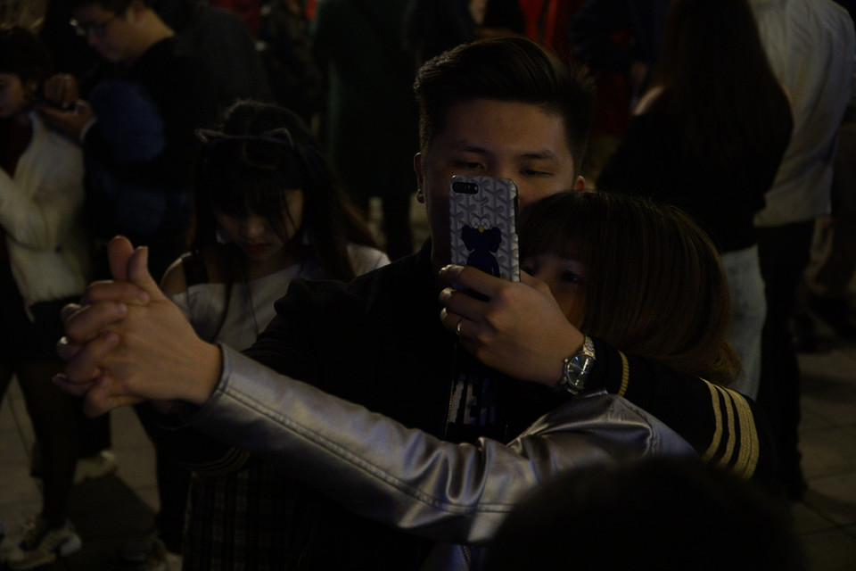 Đôi bạn trẻ đang tranh thủ ghi lại cử chỉ tình cảm đầu năm mới. (Ảnh: Minh Hiếu/Vietnam+)