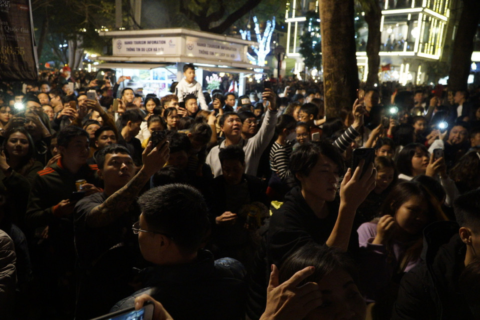 Người dân đang ghi hình thời khắc đếm ngược chuyển giao năm mới. (Ảnh: Minh Hiếu/Vietnam+)