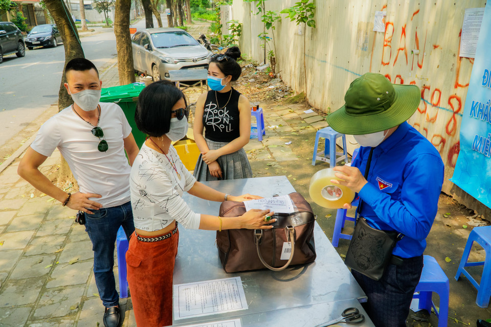 Từ khi có người về cách ly, ngày nào tại khu vực tiếp đón công dân cũng có hàng chục người thân đến gửi đồ đạc cho con, em, người thân đang cách ly bên trong. (Ảnh: Minh Hiếu/Vietnam+