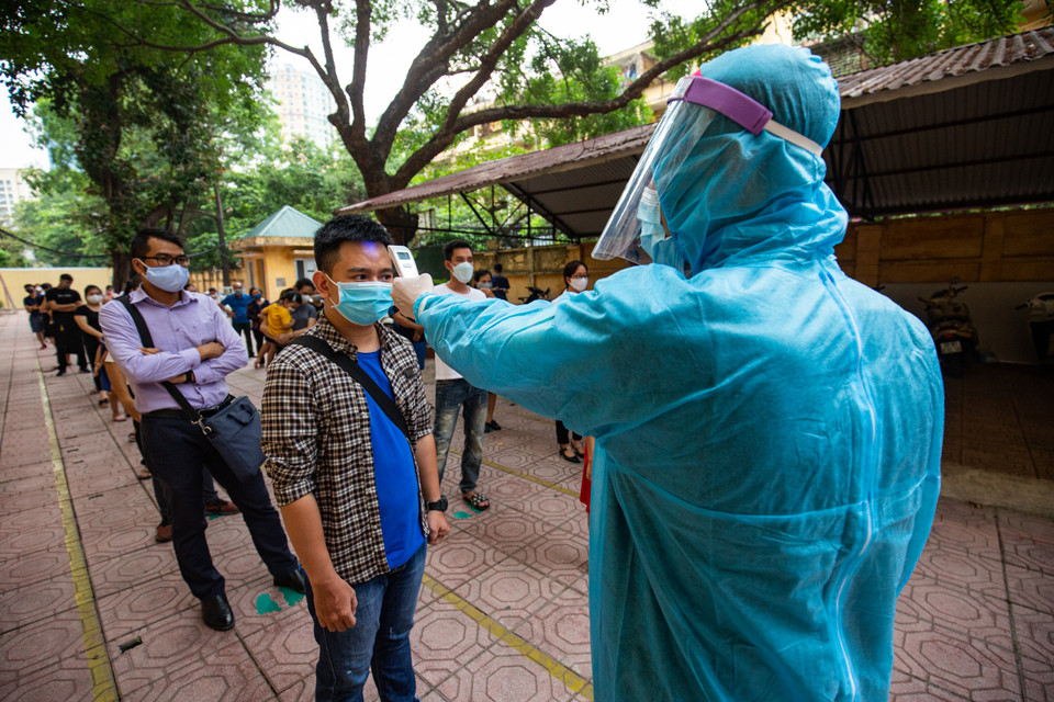 Trước khi vào xét nghiệm, người dân được bố trí đo thân nhiệt ngay từ ngoài cổng.