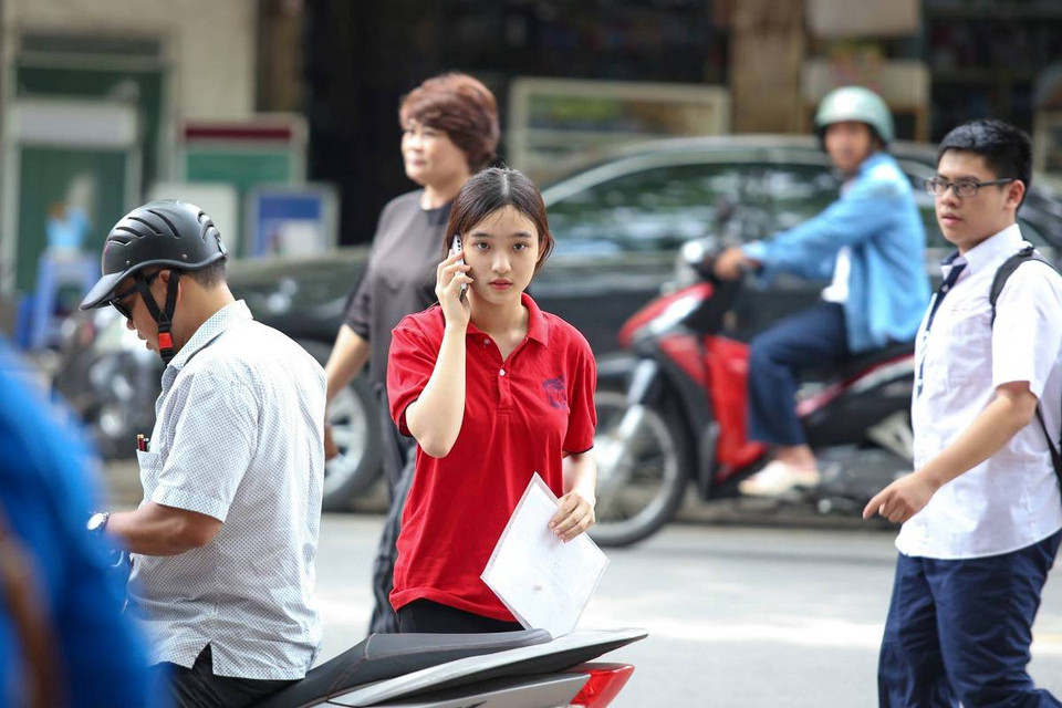 Phụ huynh chở thí sinh đến làm thủ tục tại điểm thi Trường Trung học Phổ thông Việt Đức. (Ảnh: Minh Sơn/Vietnam+)