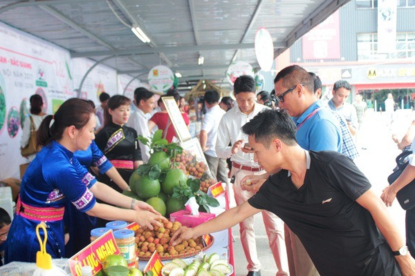 Người tiêu dùng ăn thử sản phẩm vải thiều Lục Ngạn tại các gian hàng trưng bày của Tuần lễ vải thiều. (Ảnh: Thanh Tâm/Vietnam+)