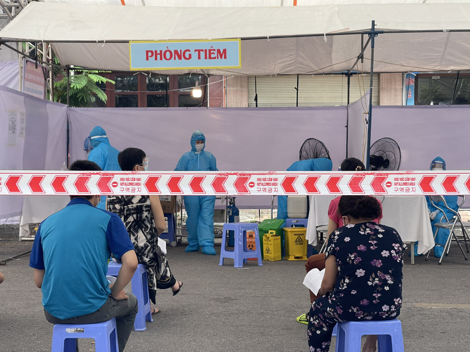 Người dân đến tiêm thực hiện nghiêm thông điệp 5K. (Ảnh: QT/Vietnam+)