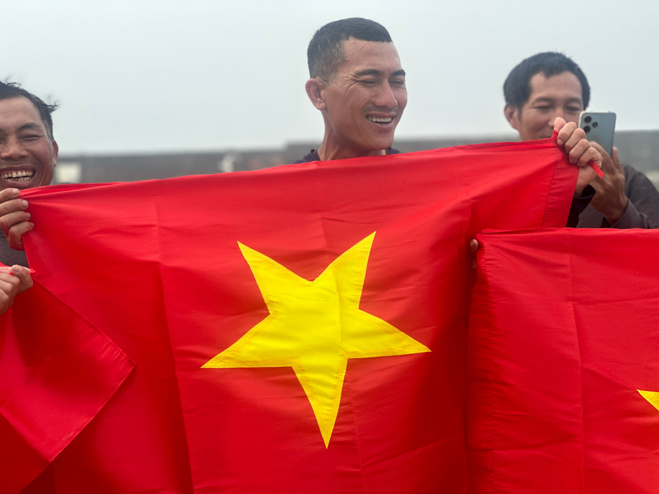 Nụ cười của ngư dân trên đảo khi nhận cờ Tổ quốc. (Ảnh: Vietnam+)