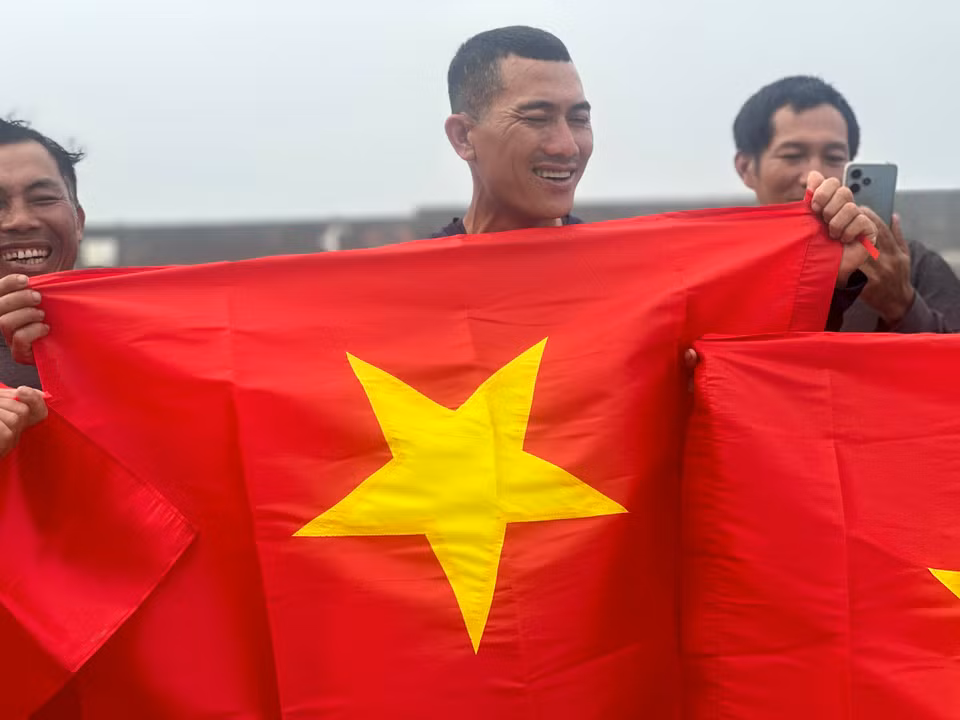 Nụ cười của ngư dân trên đảo khi nhận cờ Tổ quốc. (Ảnh: Vietnam+)