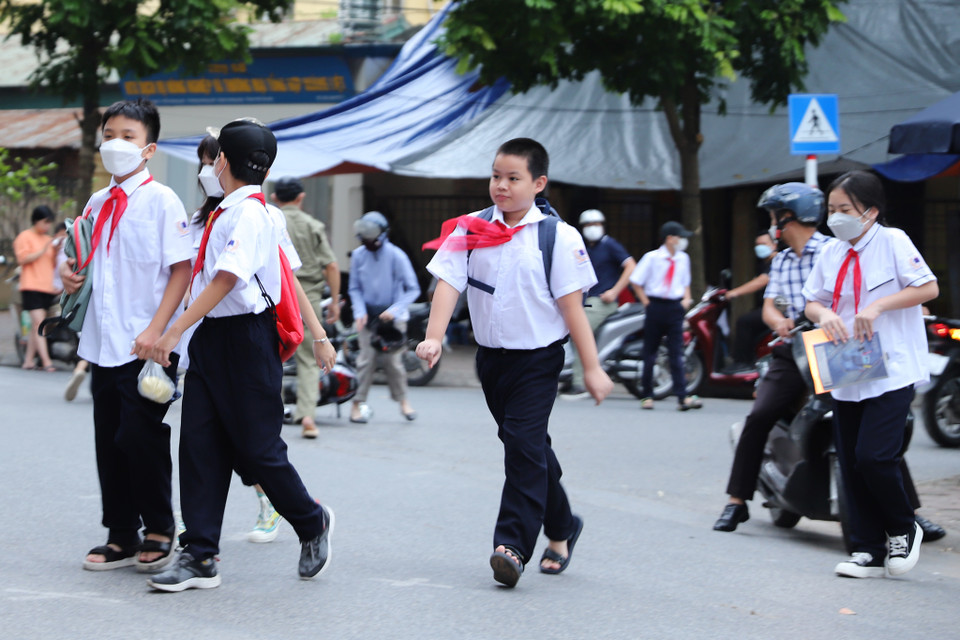 Nhiều em học sinh đã đến từ rất sớm, ai nấy đều tươi vui chào đón năm học mới. Hôm nay các em được đến trường gặp thầy cô, bạn bè thay vì tham gia lễ khai giảng trực tuyến như năm học trước. (Ảnh: Hoài Nam/Vietnam+)