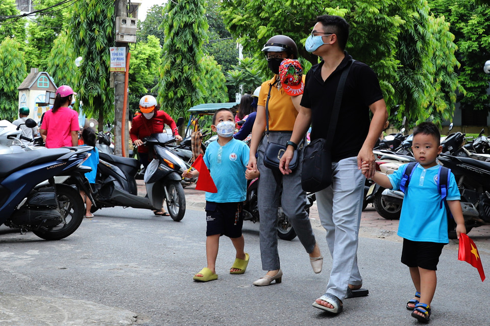 Tại trường mầm non Hoàng Liệt (Hoàng Mai, Hà Nội), các bậc phụ huynh đưa các bé đến từ sớm để tìm khu vực lớp cho con mình. (Ảnh: Hoài Nam/Vietnam+)