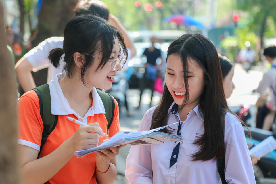 Nữ sinh THPT Trần Phú đang cùng ôn bài sớm với bạn trước khi vào thi tại điểm thi THPT Việt Đức. (Ảnh: Sơn Bách/Vietnam+)