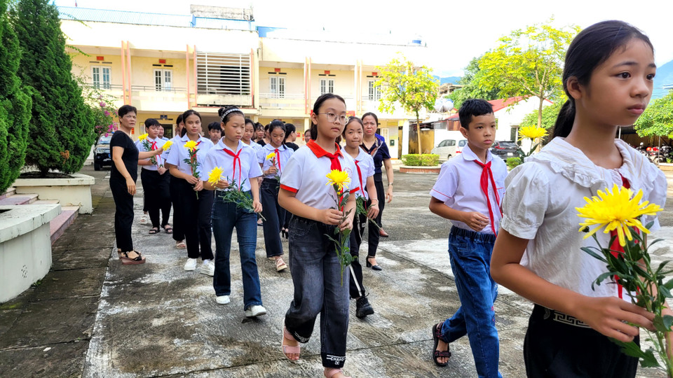 Các em học sinh Tiểu học và Trung học cơ sở Vạn Thọ cầm trên tay những bông cúc dâng lên Tổng Bí thư. (Ảnh: Minh Anh/Vietnam+)