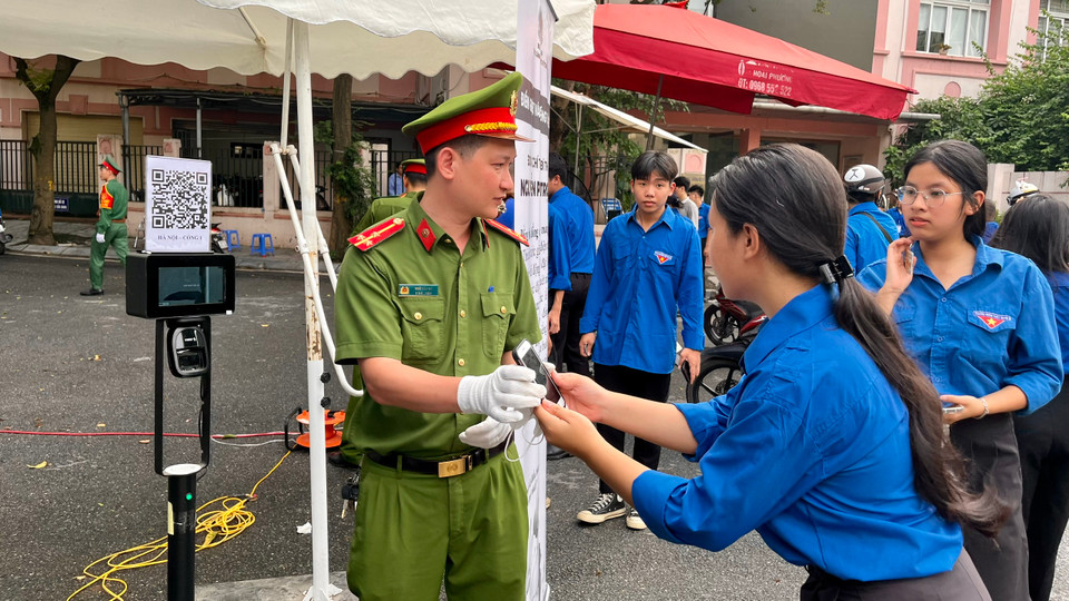Lực lượng chức năng hướng dẫn người dân quét mã vào viếng Tổng Bí thư. (Ảnh: PV/Vietnam+)
