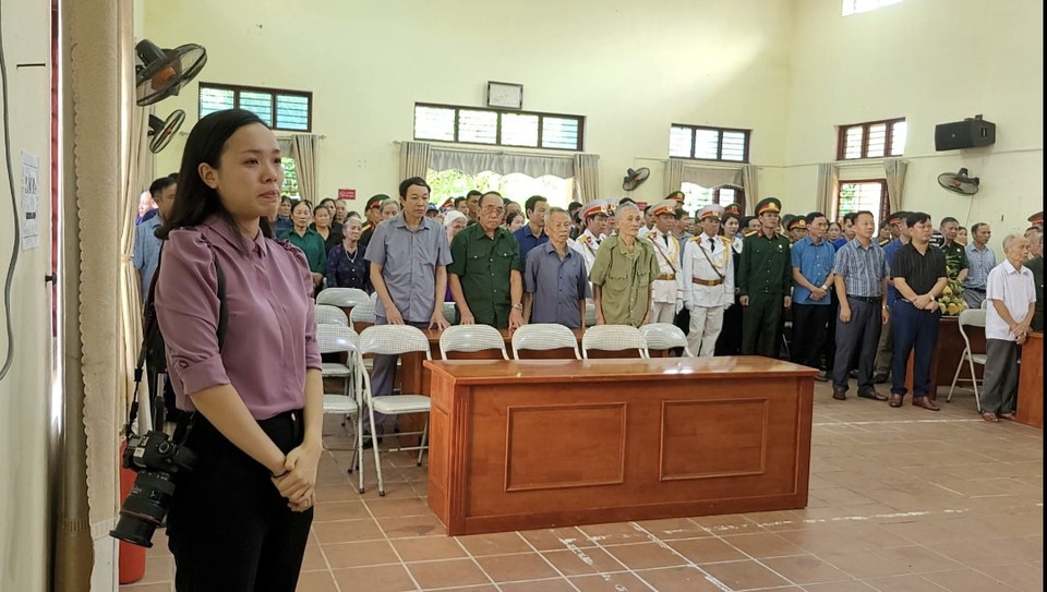 Một phóng viên địa phương xúc động, không thể cầm nước mắt khi đang tác nghiệp. (Ảnh: Minh Anh/Vietnam+)