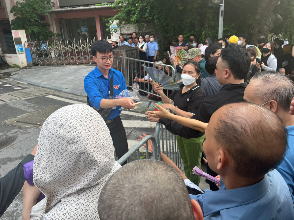 Người dân xếp hàng chờ vào viếng Tổng Bí thư Nguyễn Phú Trọng được các bạn thanh niên tình nguyện tiếp nước và bánh. (Ảnh: PV/Vietnam+)