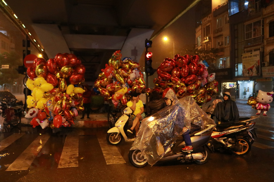 Mưa gió khiến cho người dân phải trú mưa ở dưới những chân cầu. (Ảnh: Minh Hiếu/Vietnam+)