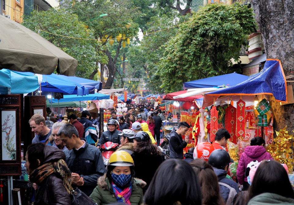 Không khí vui tươi, nhộn nhịp xen lẫn sự vội vàng, hối hả của người mua và người bán. (Ảnh: Minh Hiếu/Vietnam+)