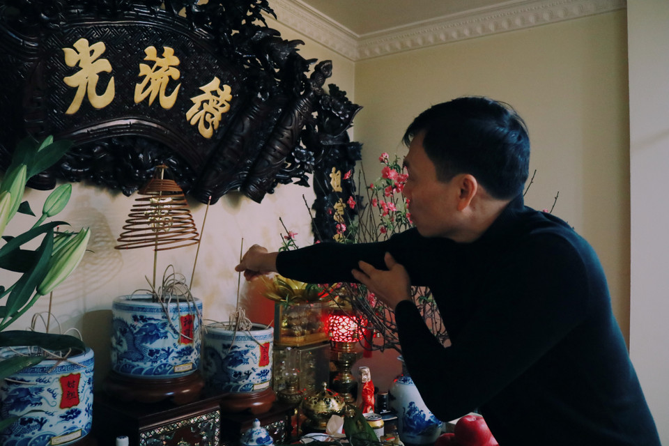 Là chủ gia đình, anh Nguyễn Văn Lợi, chồng chị Thuỷ thắp nén hương cúng gia tiên. Anh Lợi cho biết lễ cúng tất niên thường diễn ra vào buổi trưa cho đến chiều 30 tháng Chạp, trước Lễ cúng giao thừa. (Ảnh: Minh Hiếu/Vietnam+)