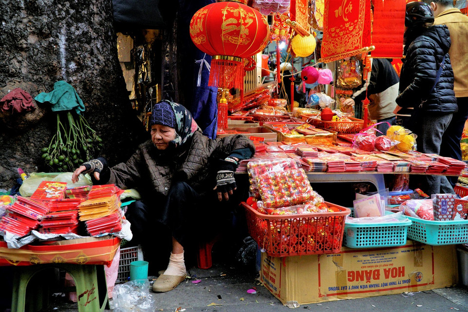 Cô bán hàng đang ngồi sắp xếp những thếp bao lì xì của mình. (Ảnh: Minh Hiếu/Vietnam+)