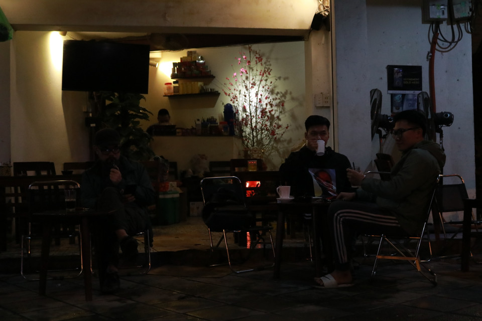 Bên cạnh đó, nhiều người chọn nhâm nhi tách cà phê dưới trời mưa. (Ảnh: Minh Hiếu/Vietnam+)