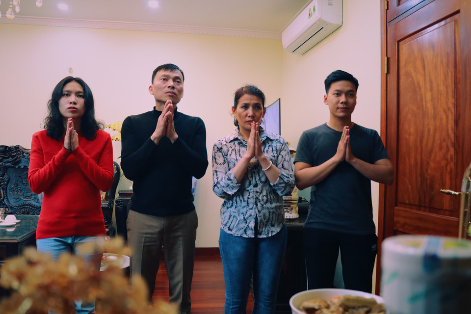 Cả gia đình cùng chắp tay làm lễ trước bàn thờ để cầu mong cho một năm mới sức khỏe, tài lộc, may mắn. (Ảnh: Minh Hiếu/Vietnam+)