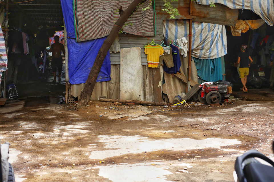 Anh Phương lên Hà Nội ở trọ cùng hơn 30 công nhân khác từ nhiều tỉnh thành. Không gian lán trọ được dựng tạm bợ, hơi nóng trên ngói fibro hất xuống nóng đến mức mọi người ở đây phải bơm nước khắp xung quanh khu trọ, từ trong ra ngoài. (Ảnh: Phương Linh/Vietnam+)