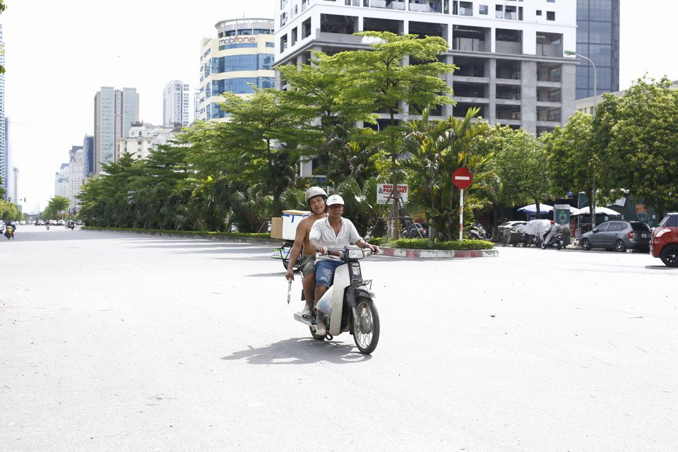 Sau khi kết thúc công việc, anh vẫn chưa thoát khỏi sự mệt mỏi khi về lán trọ giữa trời nắng. Những cung đường "đổ lửa" khiến quãng đường về nhà trở nên dài hơn. (Ảnh: Phương Linh/Vietnam+)