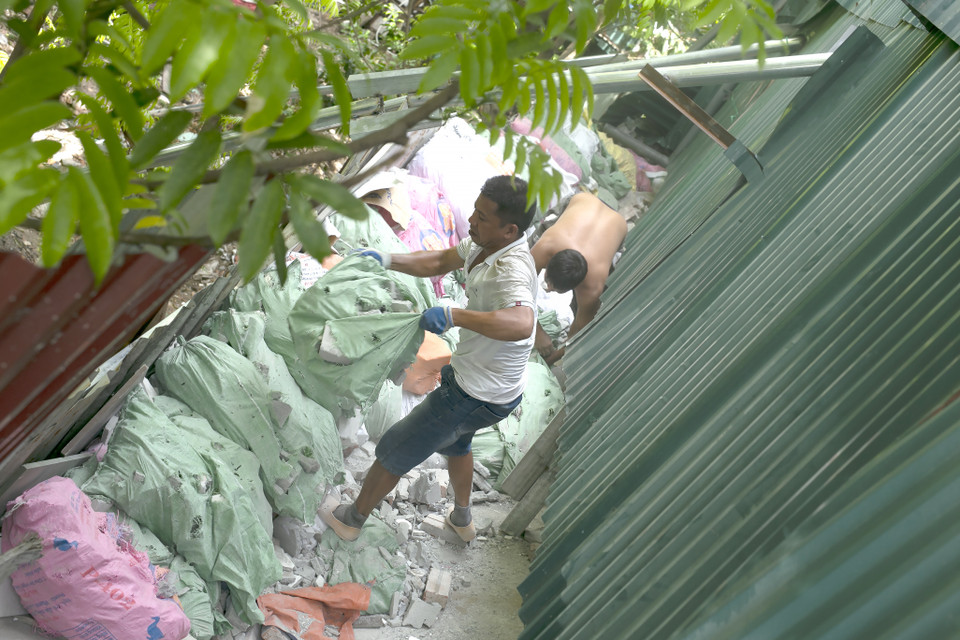 Gần trăm bì bê tông, nền gạch từ bên trong được khuân ra để ke đường bờ kho. (Ảnh: Phương Linh/Vietnam+)