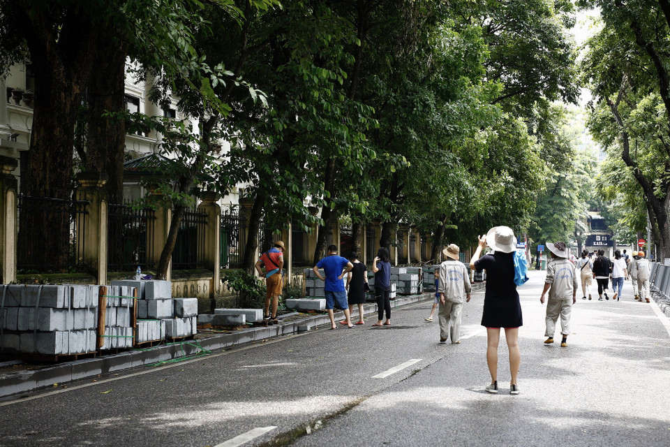 Vợ chồng anh Sơn thuộc nhóm khách du lịch từ Sài Gòn ra Hà Nội chơi vài ngày, họ quan tâm đặc biệt đến dự án lần này dù là khách ở phương xa. Anh Sơn cho biết: “Thực sự theo hiểu biết đôi chút về xây dựng, tôi nghĩ đây không phải là đá tự nhiên, mà nếu thật sự là đá tự nhiên thì liệu có cần phải dùng đến viên đá có độ dày lớn vậy không? Vì đá tự nhiên rất cứng cáp, độ dày một nửa vừa đảm bảo chất lượng vừa giảm được chi phí.” (Ảnh: Phương Linh/Vietnam+)
