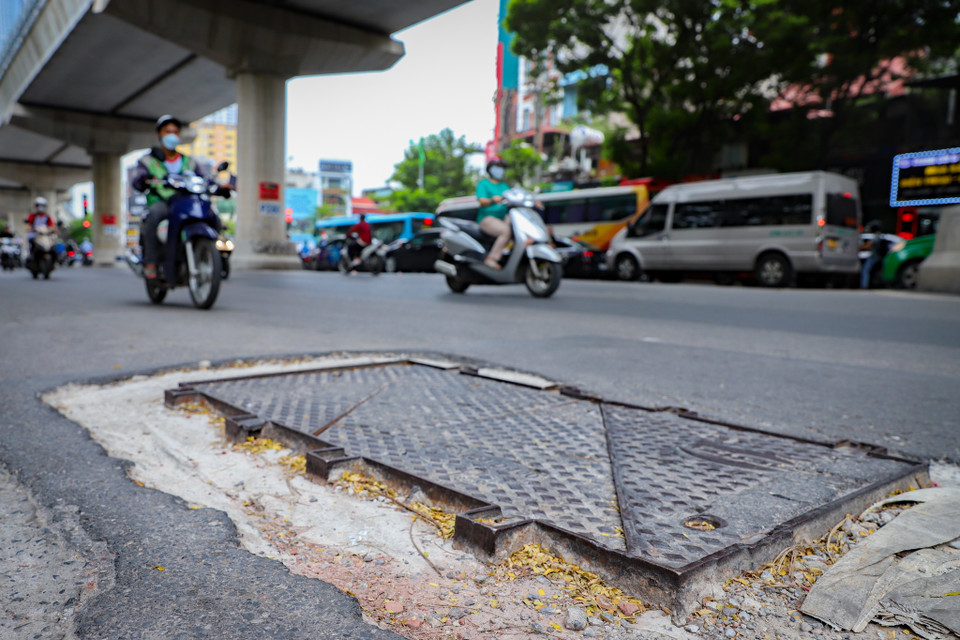 Nắp một hố ga tại 36 Xuân Thủy (Cầu Giấy, Hà Nội) nhô cao hẳn so với mặt đường, không những thế còn được điểm thêm các góc cạnh trên nền bê tông "lở loét". (Ảnh: Hoài Nam/Vietnam+)