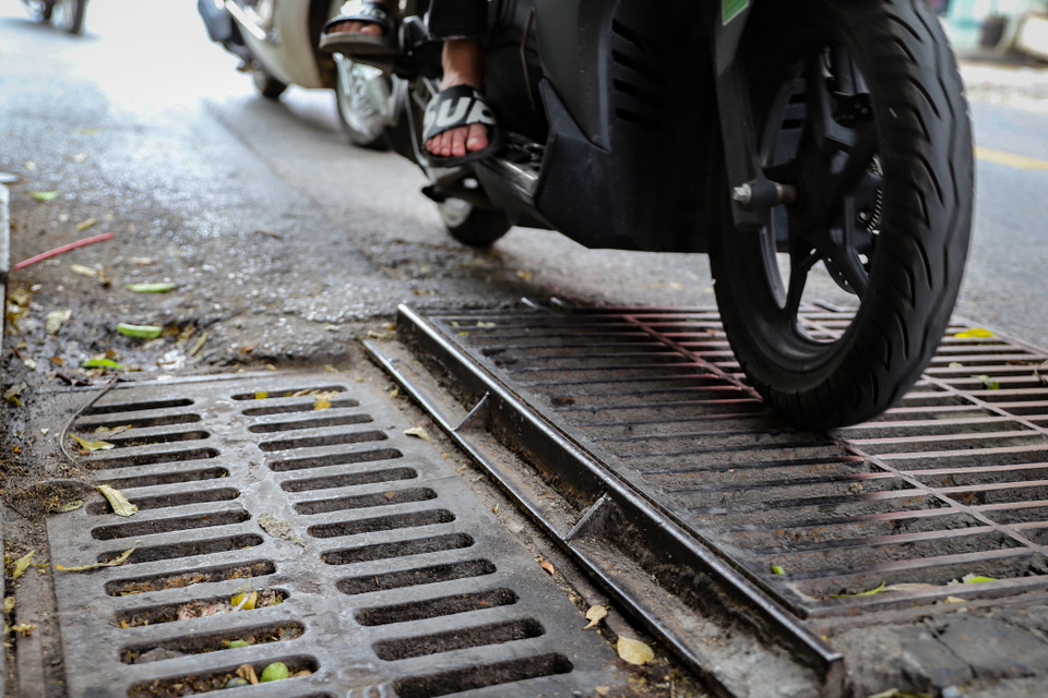 Không chỉ là những ‘cái bẫy’ gây mất an toàn cho người tham gia giao thông, những miệng cống, hố ga còn là những‘vết sẹo’ xấu xí, khắc khổ trên bộ mặt của đô thị Hà Nội. (Ảnh: Hoài Nam/Vietnam+)