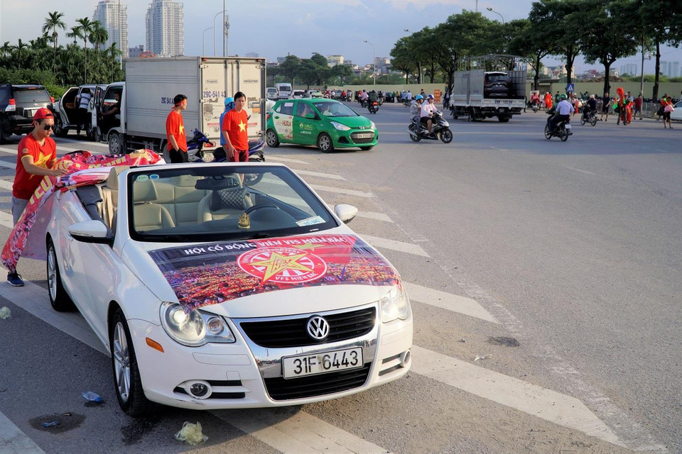 Cổ động viên dán áp phích cổ vũ khắp trên tuyến đường. (Ảnh: Minh Hiếu/Vietnam+)