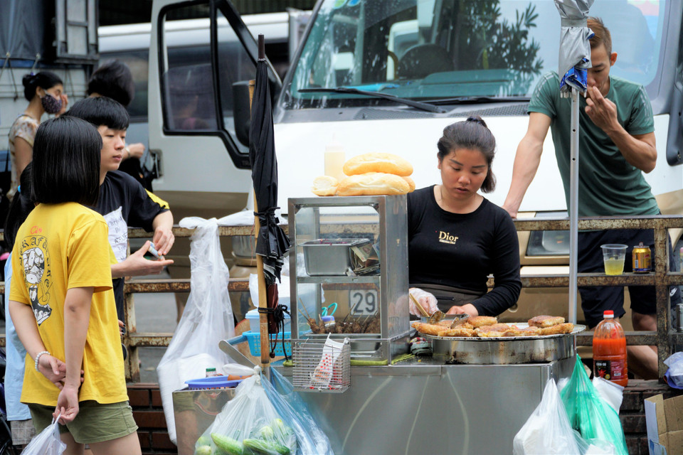 Những xe bán bánh chưng rán nóng hổi bỗng dưng đắt khách. (Ảnh: Minh Hiếu/Vietnam+)