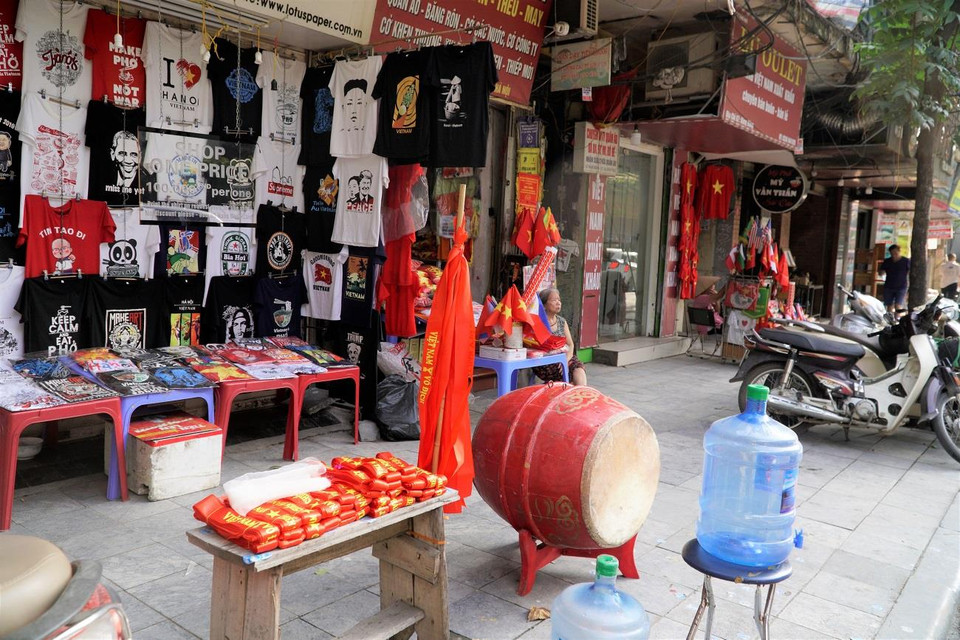 Cờ đỏ, băng rôn cổ vũ được bày bán trên tuyến phố Hàng Bông, sẵn sàng phục vụ người hâm mộ Việt Nam. (Ảnh: Minh Hiếu/Vietnam+)