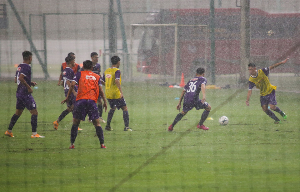 Buổi tập đầu tiên diễn ra dưới thời tiết không thuận lợi khi có cơn mưa lớn trút xuống ngay sau phần khởi động của U22 Việt Nam. (Ảnh: PV/Vietnam+)