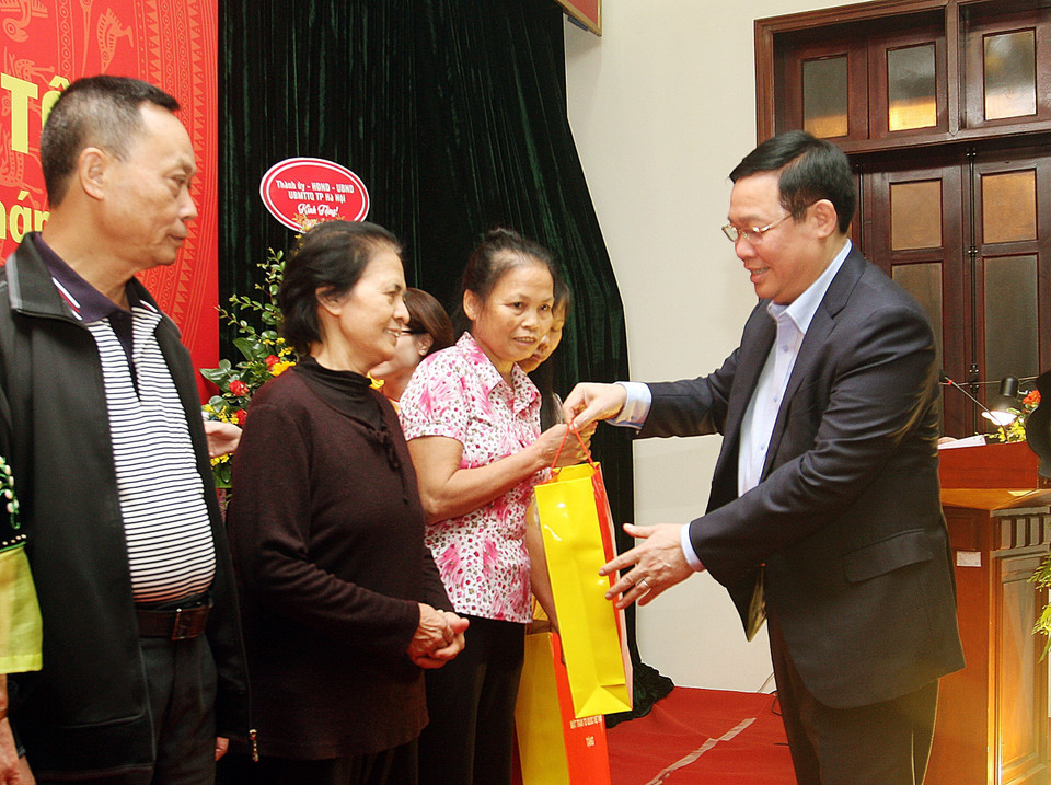 Uỷ viên Bộ Chính trị, Phó Thủ tướng Chính phủ Vương Đình Huệ tặng quà cho các gia đình thuộc địa bàn dân cư số 6 và số 9, phường Quán Thánh, quận Ba Đình. (Ảnh: Nguyễn Dân/TTXVN)