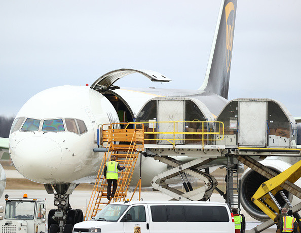 Các kiện chứa vắcxin phòng COVID-19 được đưa lên máy bay vận chuyển của USPS. (Ảnh: Getty)