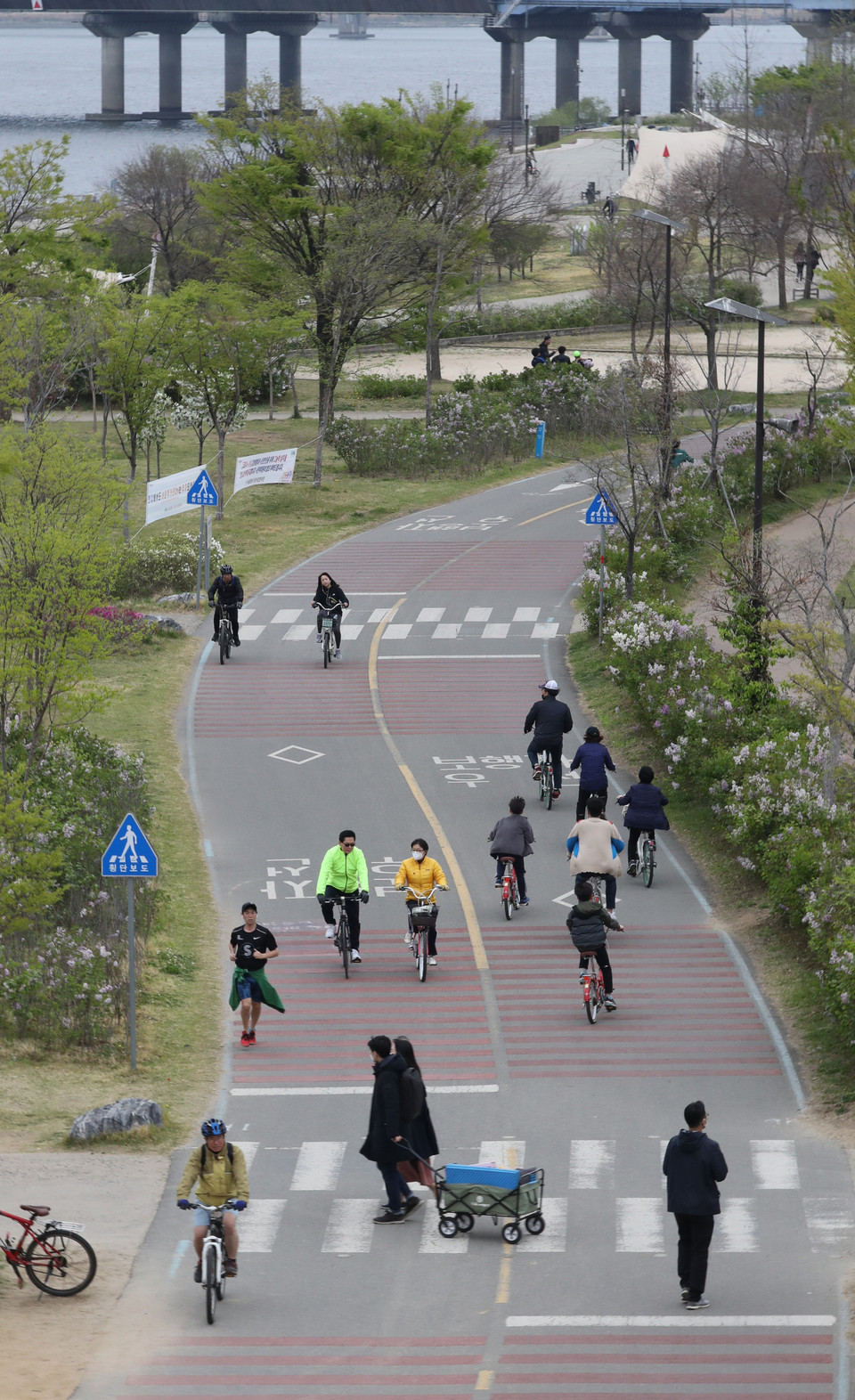 Người dân đi xe đạp trong công viên tại Yeouido, phía tây thủ đô Seoul, Hàn Quốc, ngày 19/4/2020. (Ảnh: Yonhap/ TTXVN)