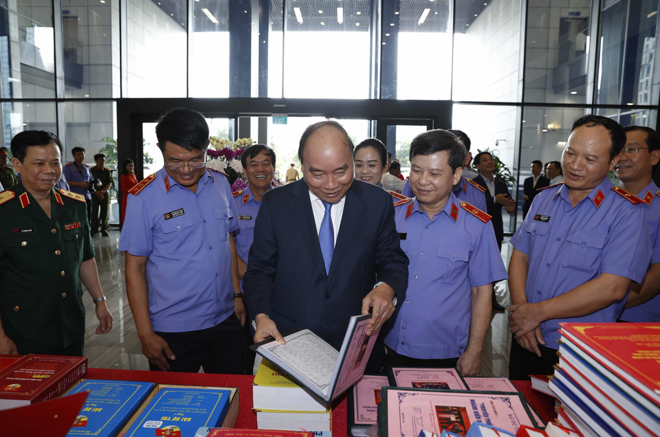 Thủ tướng Nguyễn Xuân Phúc và đại biểu xem các tác phẩm được giải về ngành Kiểm sát. (Ảnh: Thống Nhất/TTXVN)