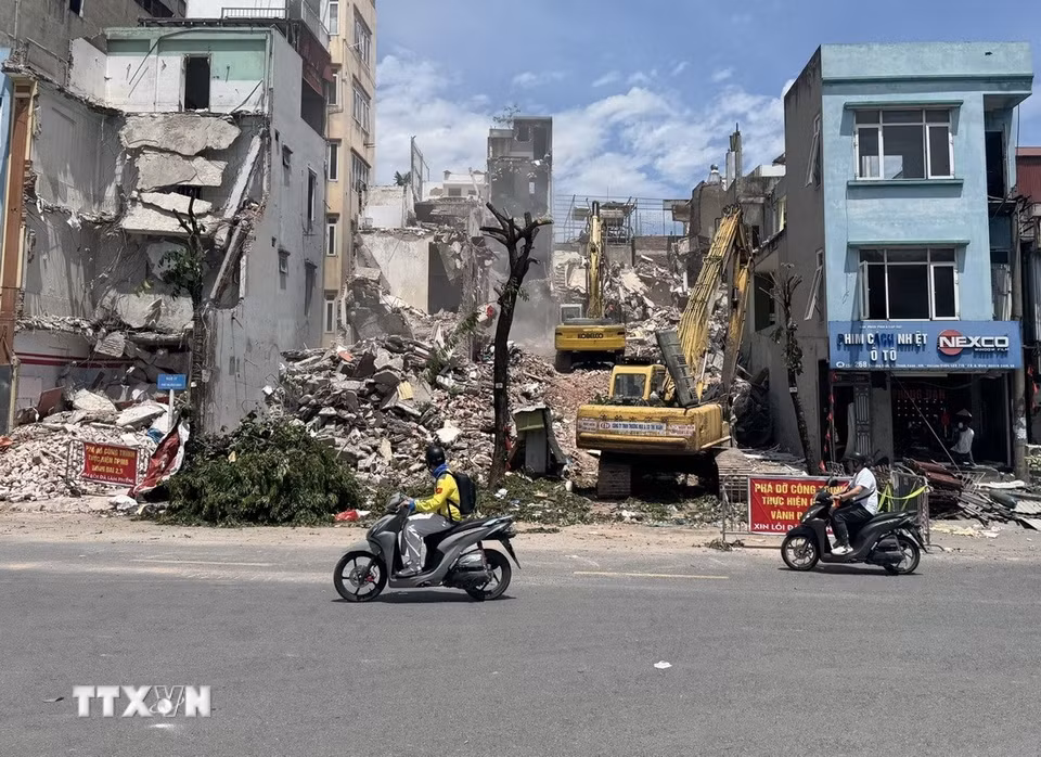 Người tham gia giao thông vất vả di chuyển dưới hơi nóng hầm hập phả lên từ mặt đường và khói bụi từ công trường. (Ảnh: Quốc Lũy/TTXVN)