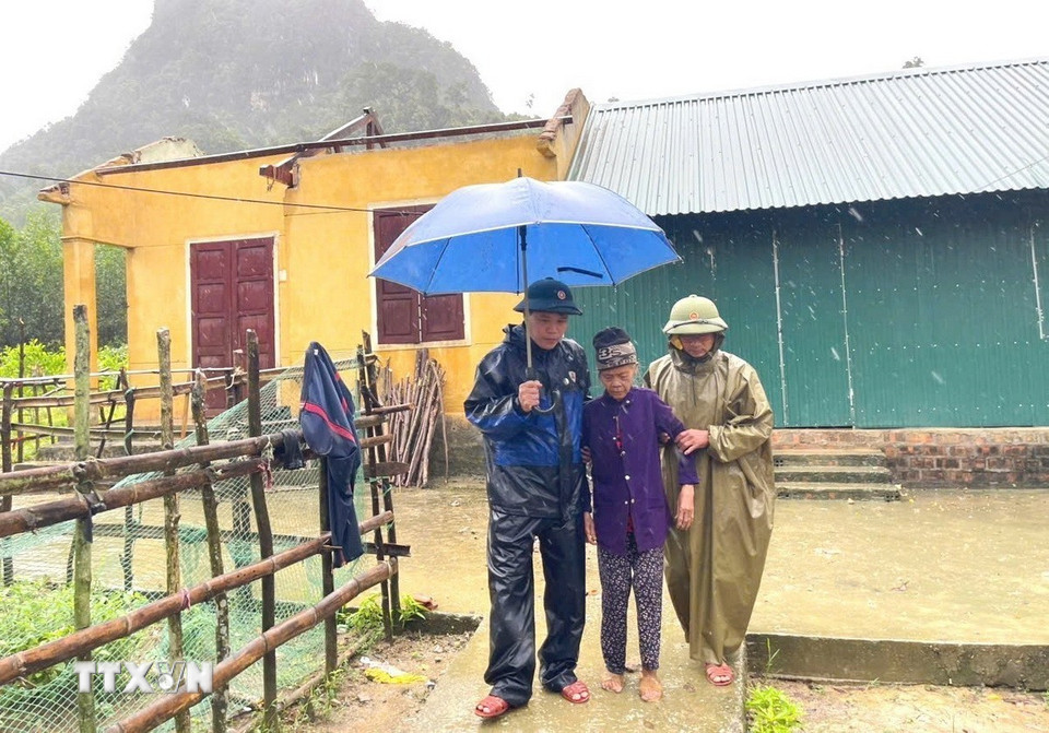 Lực lượng Biên phòng và chính quyền địa phương hỗ trợ di dời các hộ dân bị ảnh hưởng do mưa bão đến nơi tránh trú an toàn. (Ảnh: TTXVN phát)