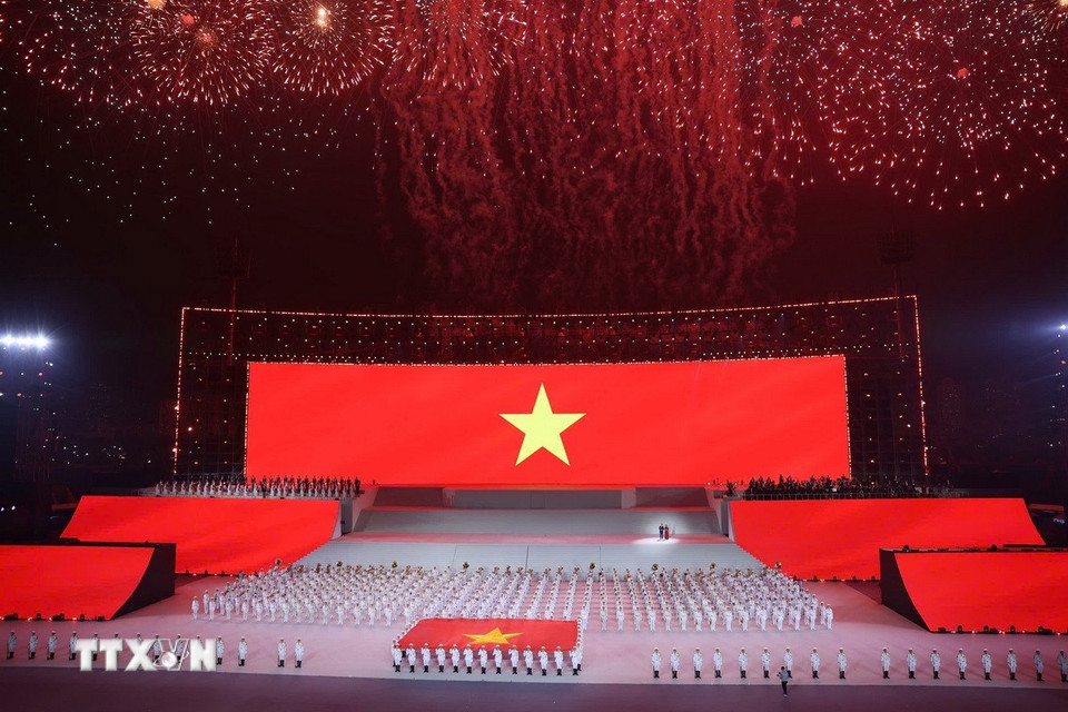 Đại biểu cùng khán giả thực hiện nghi lễ chào cờ. (Ảnh: TTXVN)