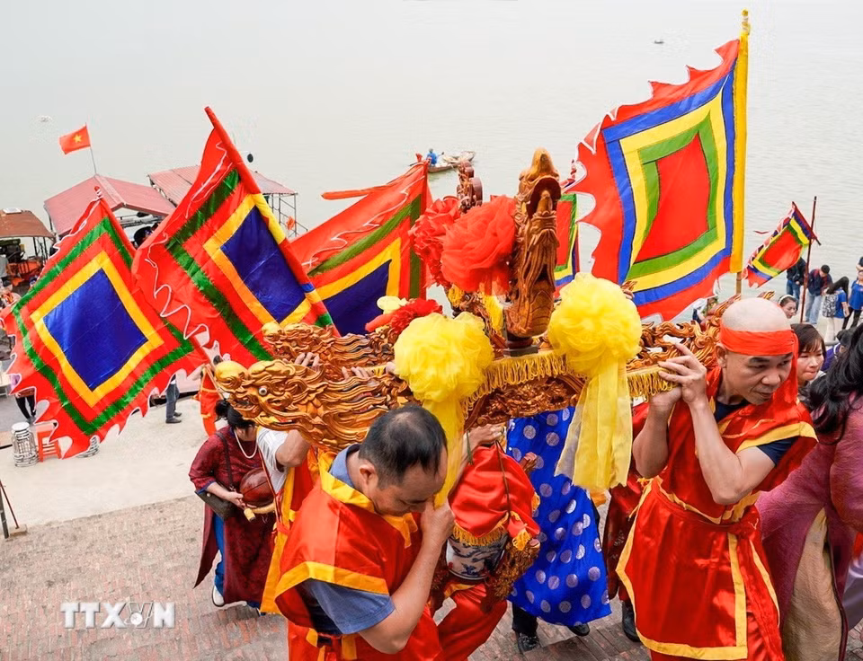 Nghi lễ rước nước từ sông Hồng về đình làm lễ tế. (Ảnh: Khánh Hoà/TTXVN)