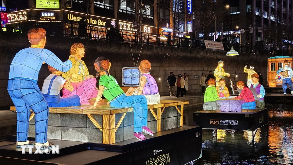 Cả nhà quây quần bên tivi đen trắng. (Ảnh: Đức Thắng/TTXVN)