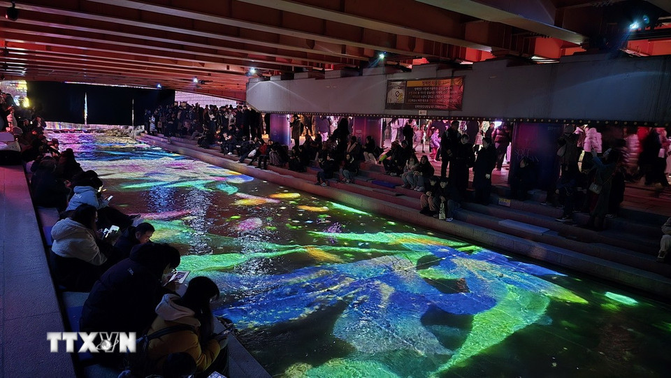 Du khách trầm trồ với những hình ảnh sống động trong lòng suối Cheonggye. (Ảnh: Đức Thắng/TTXVN)