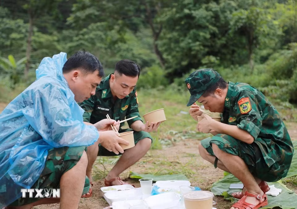 Bữa cơm trưa vội vã của các lực lượng giúp dân Bản Chít xã Mường Than khắc phục hậu quả thiên tai. (Ảnh: Quý Trung/TTXVN)
