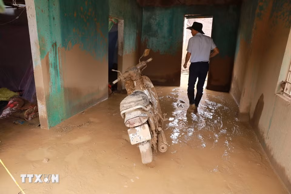 Nhiều ngôi nhà bị lũ cuốn trôi và ngổn ngang bùn đất sau khi cơn lũ đi qua. (Ảnh: Quý Trung/TTXVN)