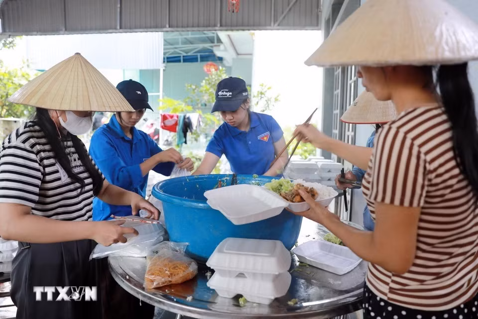 Mỗi người một việc góp phần chế biến những suất cơm nhanh nhất đưa đến giúp Mường Than. (Ảnh: Quý Trung/TTXVN)